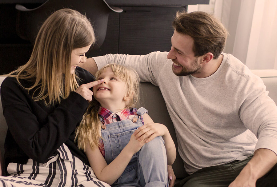 A family sitting together on the couch in their nicely heated home