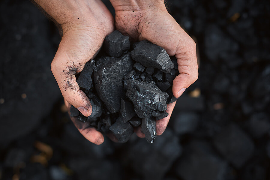 A man holding coal stones